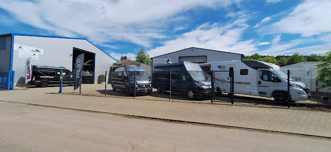 Vor den Hallen von Mosel Caravan stehen mehrere Wohnmobile auf dem Gelände.